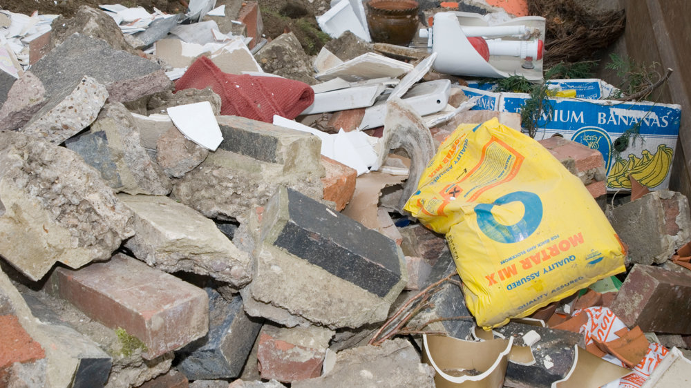 Large amount of concrete waste with yellow bag to top of rubble